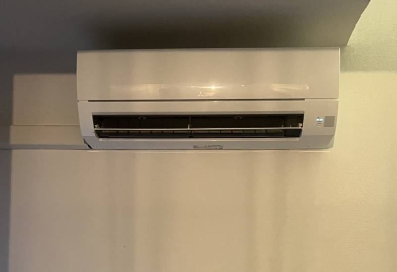 Pose d'une unité murale Mitsubishi Electric monosplit dans un salon à Martigues par l'équipe d'AM Service.